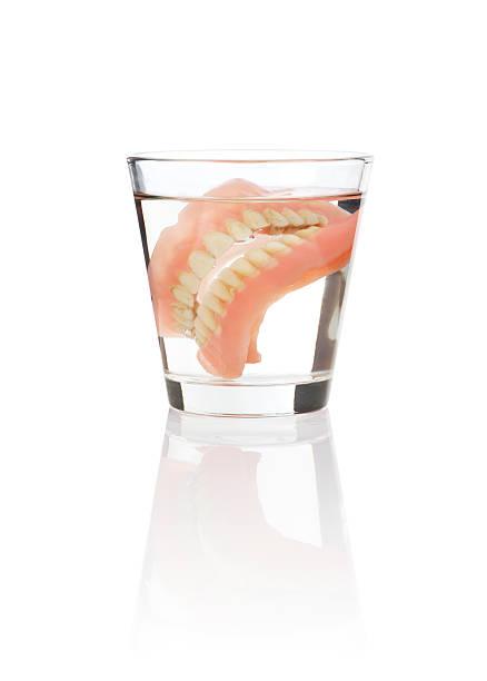 set-of-dentures-being-soaked-in-a-glass-